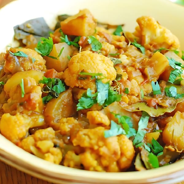 Close-up of Kesar's Indian Aloo Gobi, a cauliflower and potato curry, garnished with fresh cilantro.